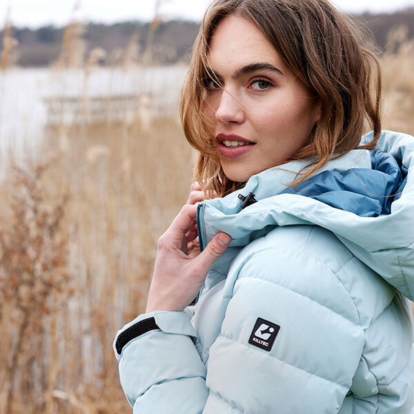 Eine Frau mit einer Jacke von Killtec am See